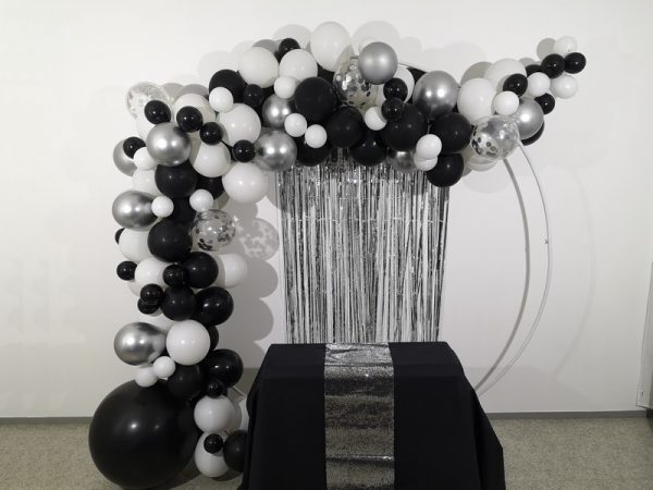 Une très jolie arche de ballons noir, blanc et argent, idéale pour une décoration chic et tendance.